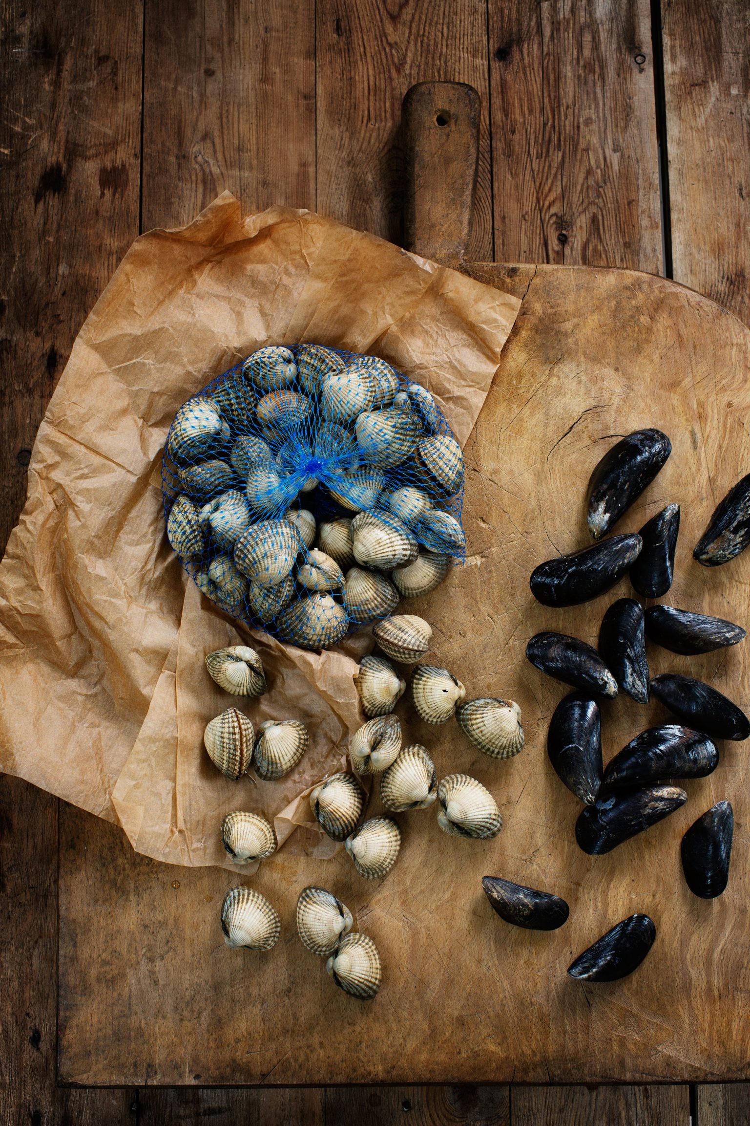 a bag of clams and mussels on a wooden surface