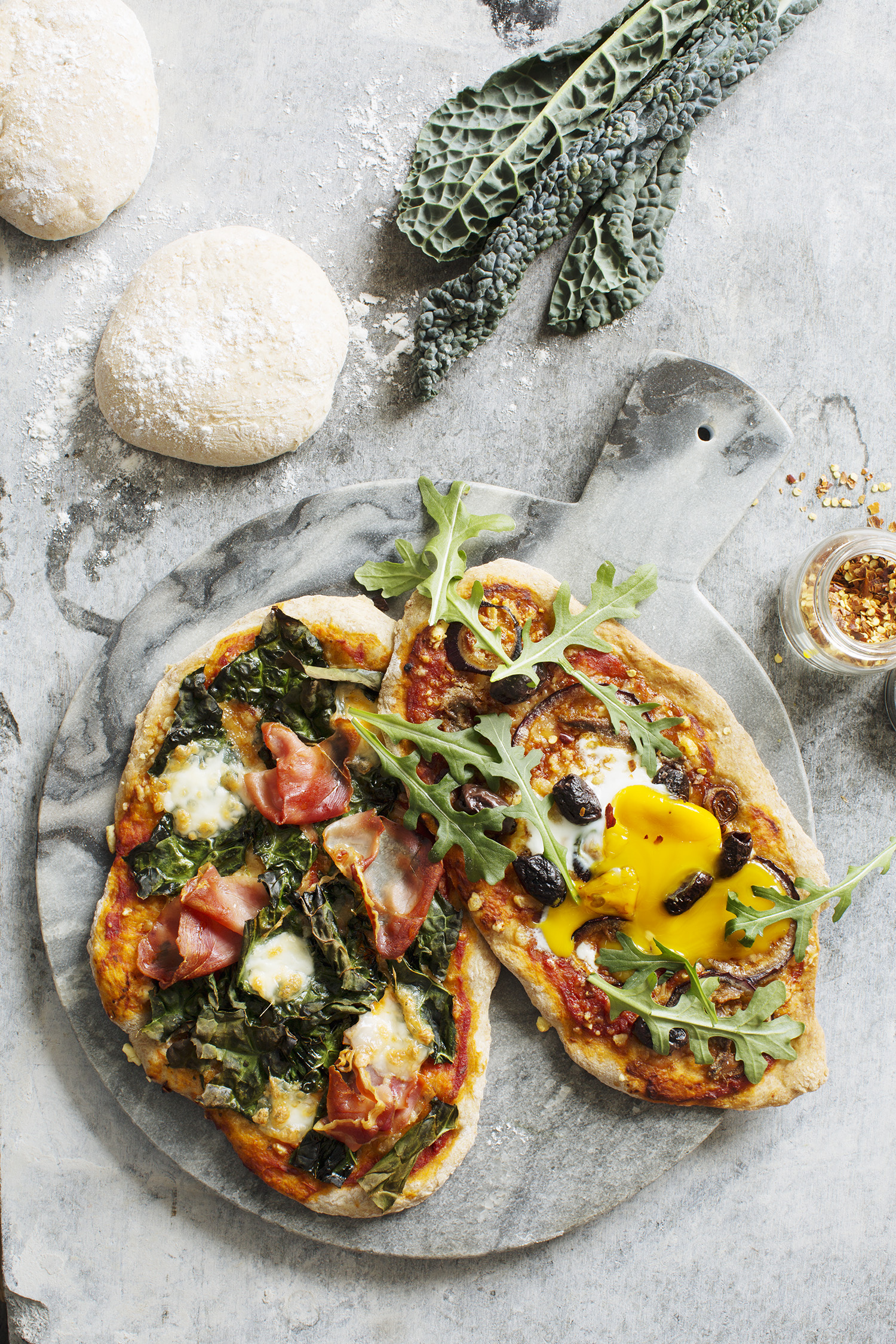 a pizza with vegetables on a cutting board