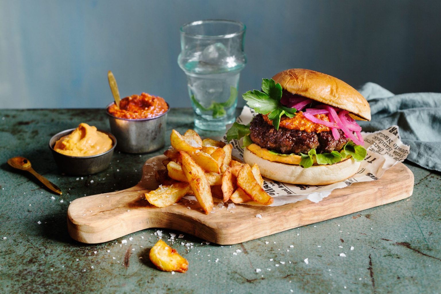 a burger and fries on a cutting board