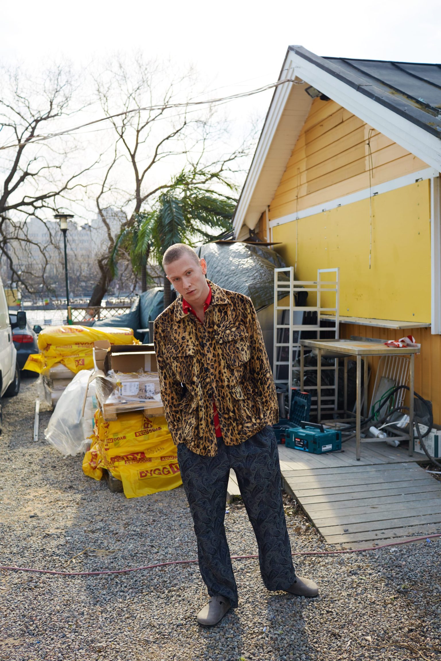 a man standing outside a yellow house
