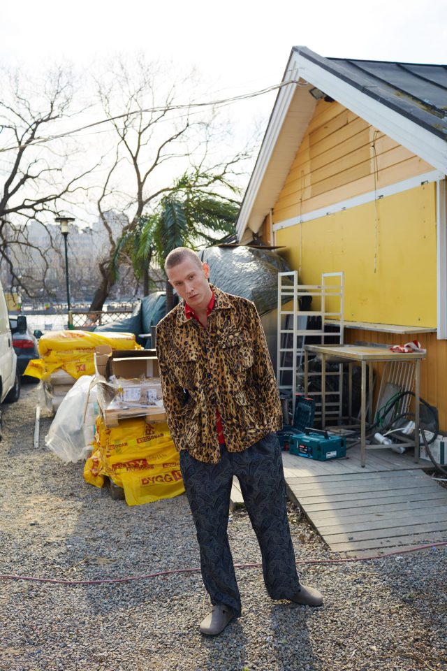 a man standing outside a yellow house