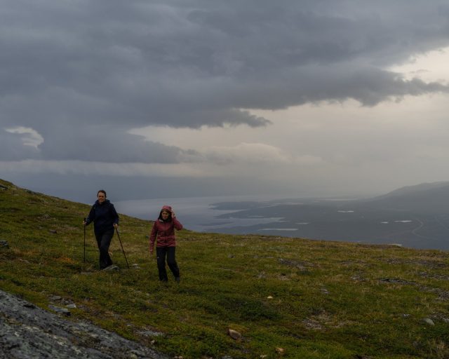 two people hiking on a hill