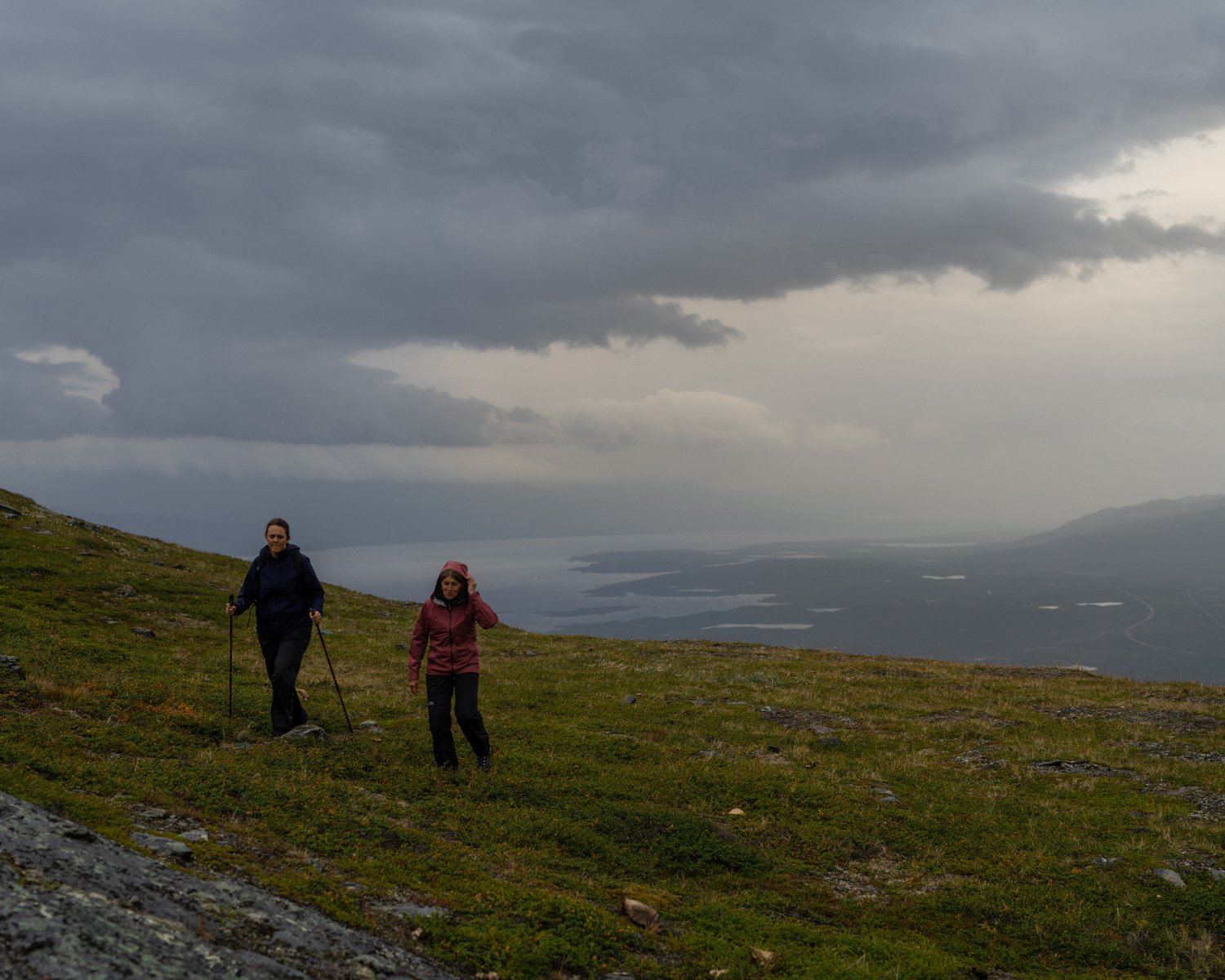 two people hiking on a hill