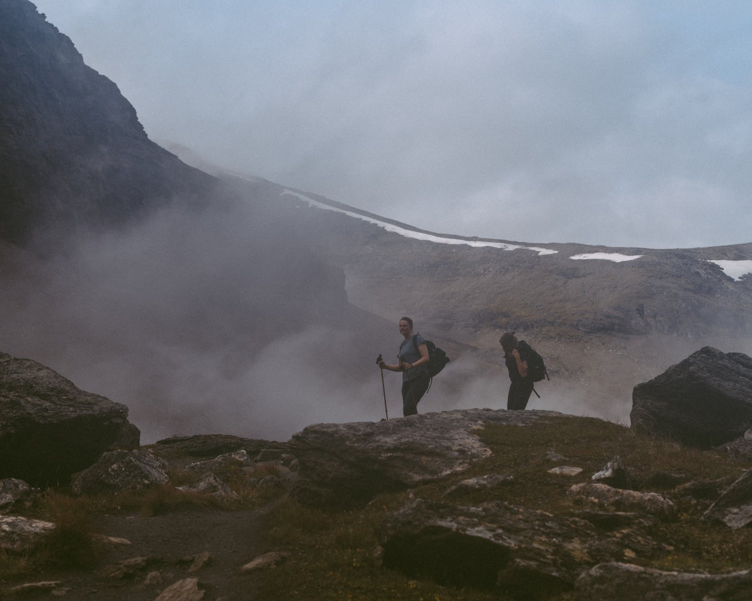a couple of people hiking on a rocky mountain
