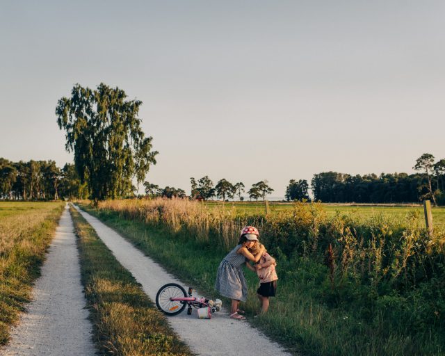 two children kissing on a path