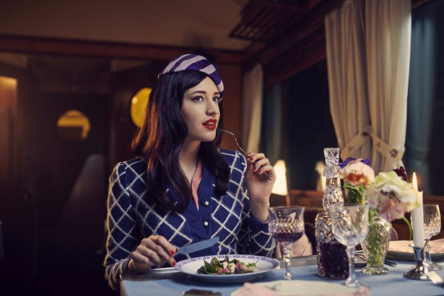 a woman sitting at a table with a plate of food