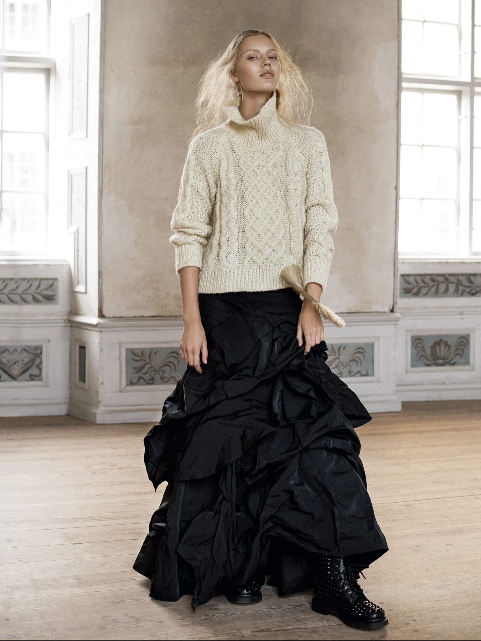 a woman in a white sweater and black skirt