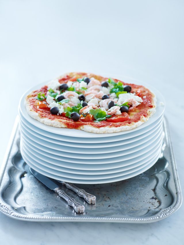 a stack of plates with pizza on top
