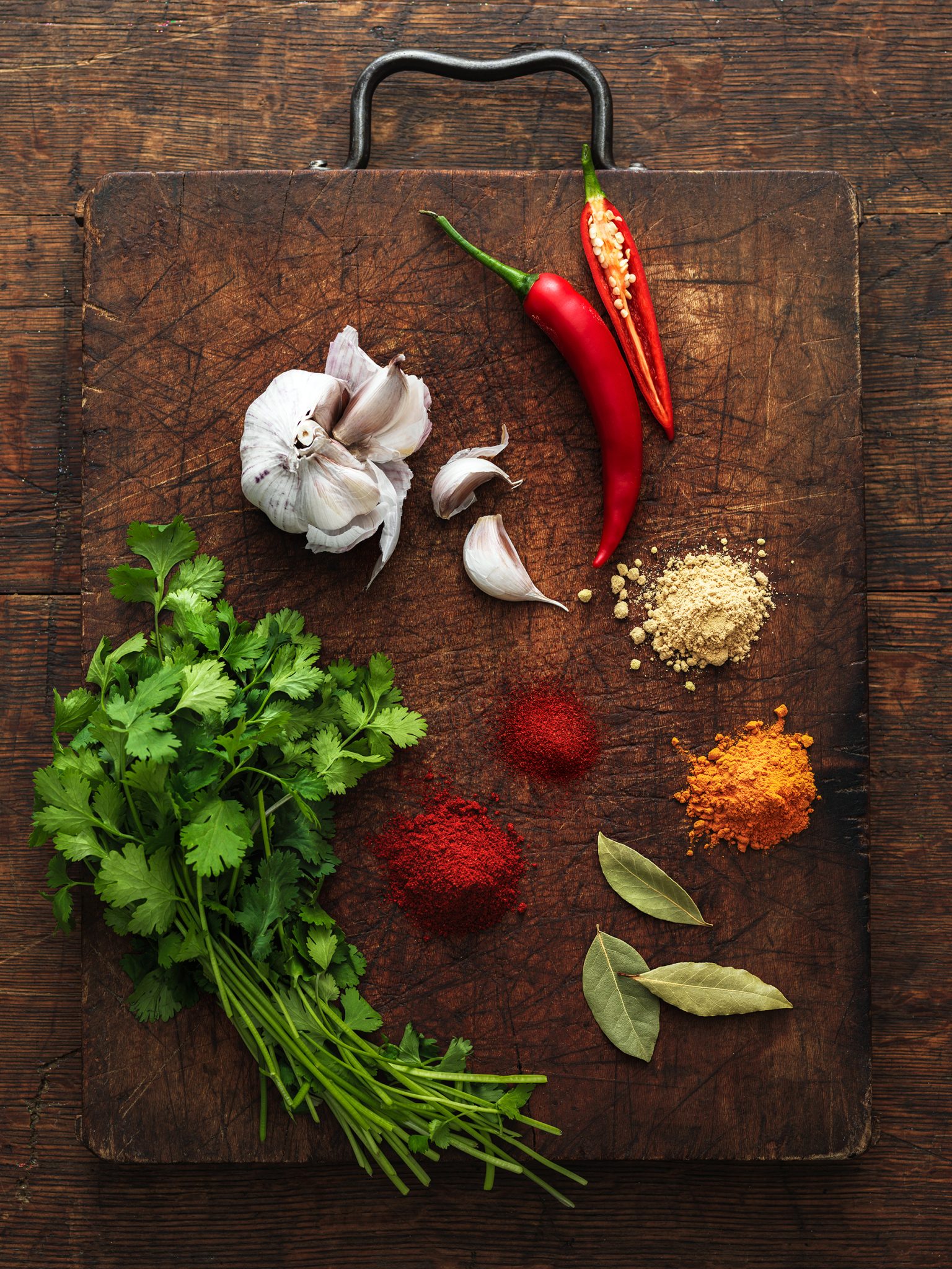 a group of spices and herbs on a cutting board