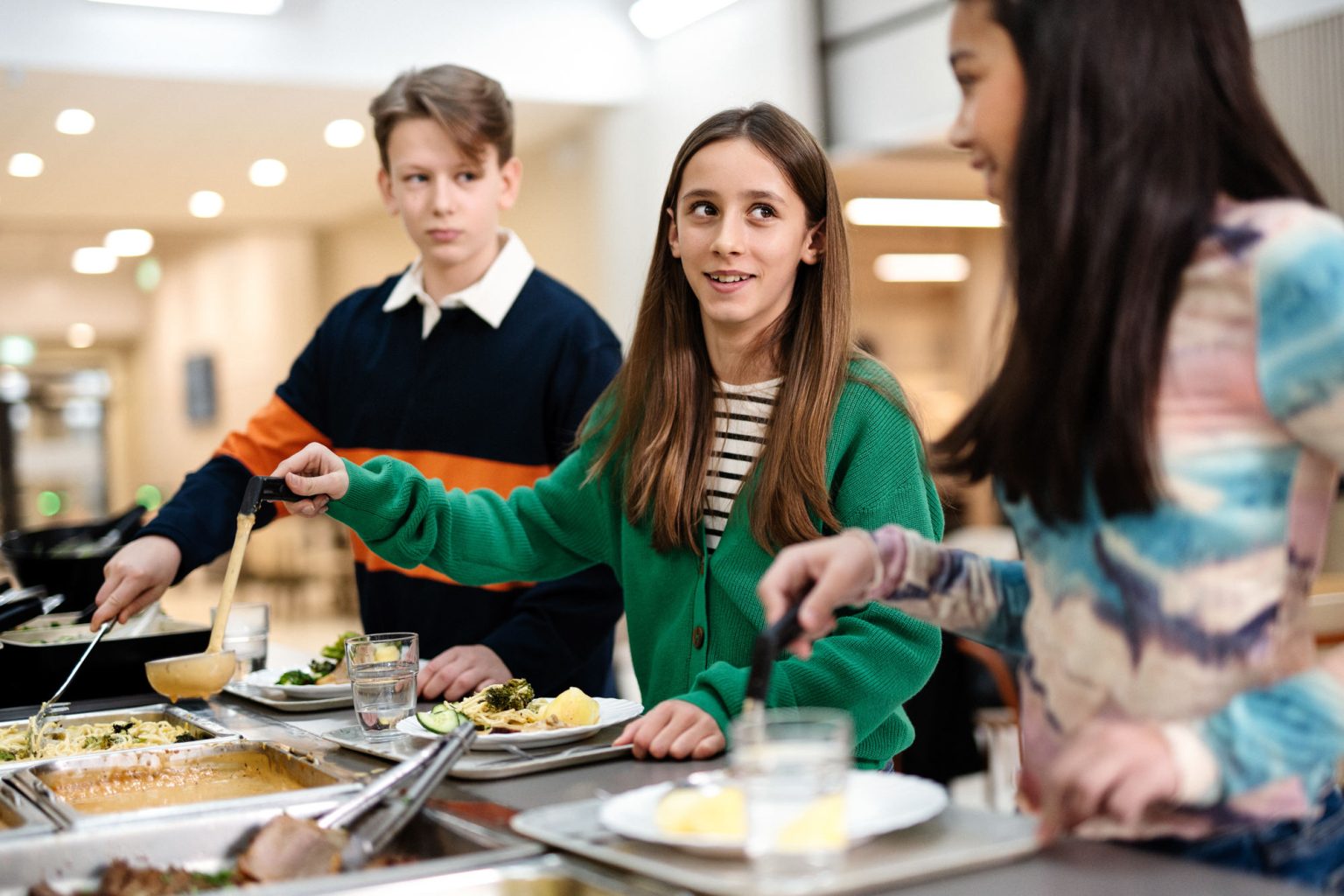 a group of kids standing around a table with food