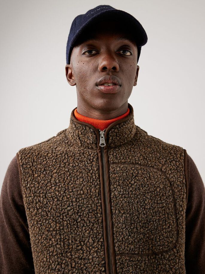 a man wearing a hat and vest