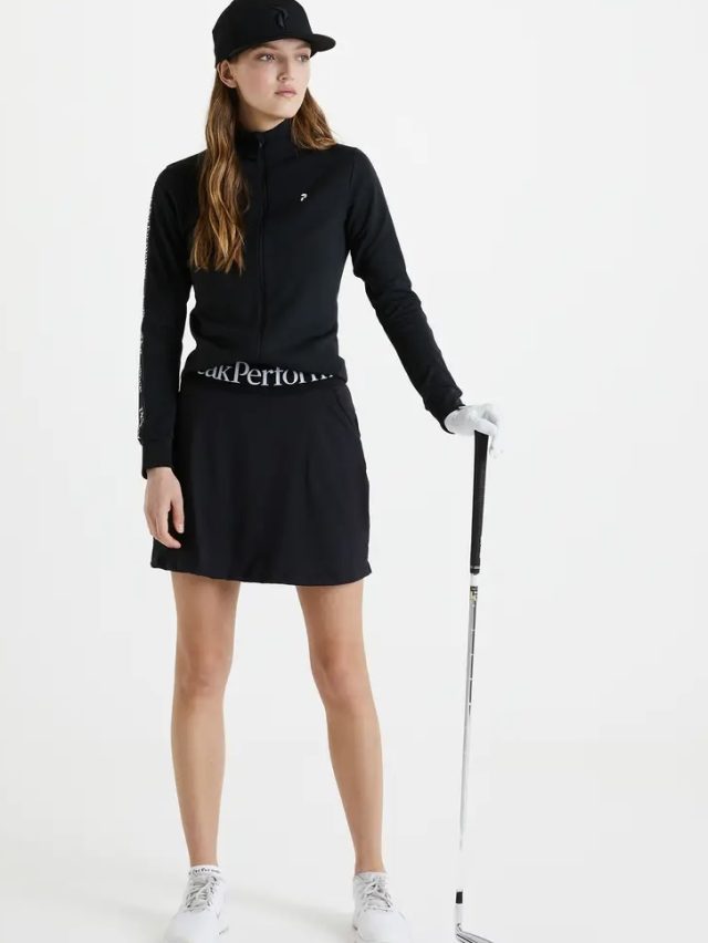 a woman in a black outfit holding a golf club
