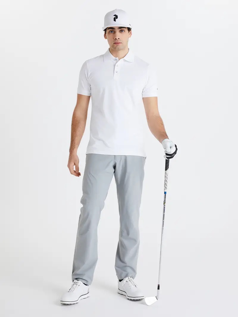 a man in a white shirt and grey pants holding a golf club