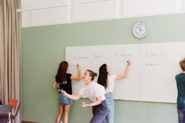 a group of women writing on a whiteboard