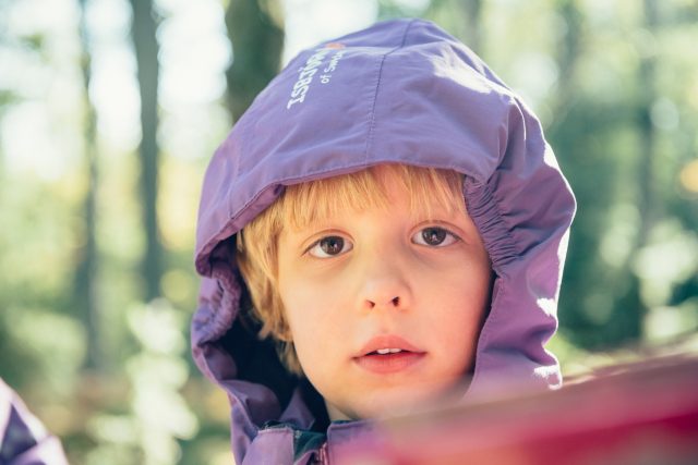 a child wearing a purple hood