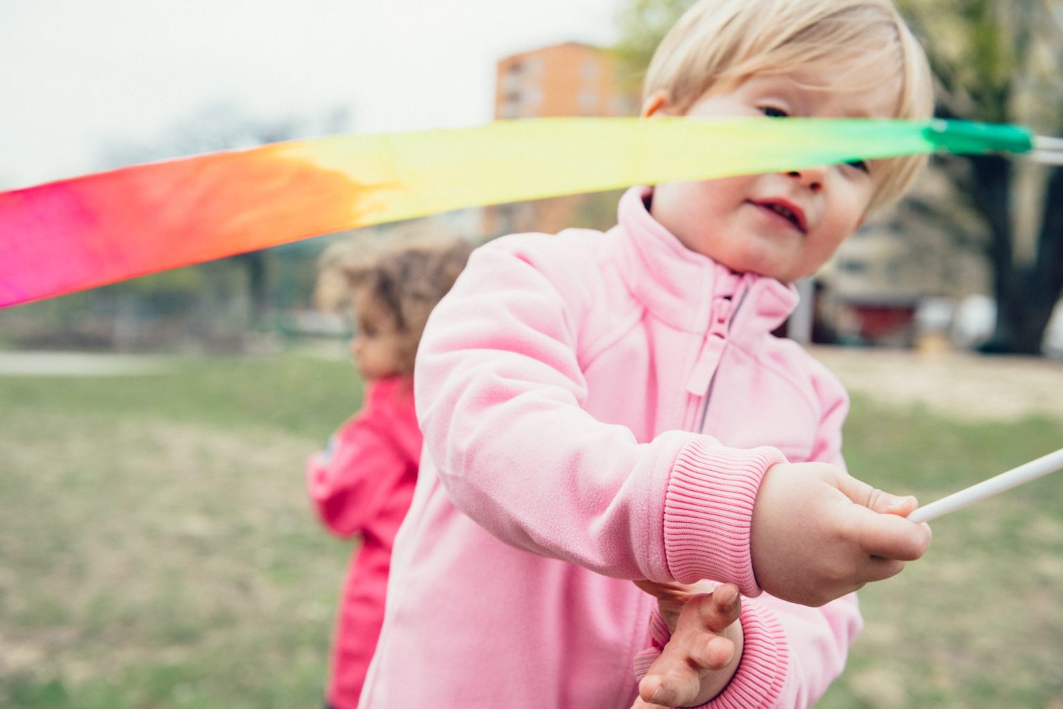 a child playing with a colorful ribbon