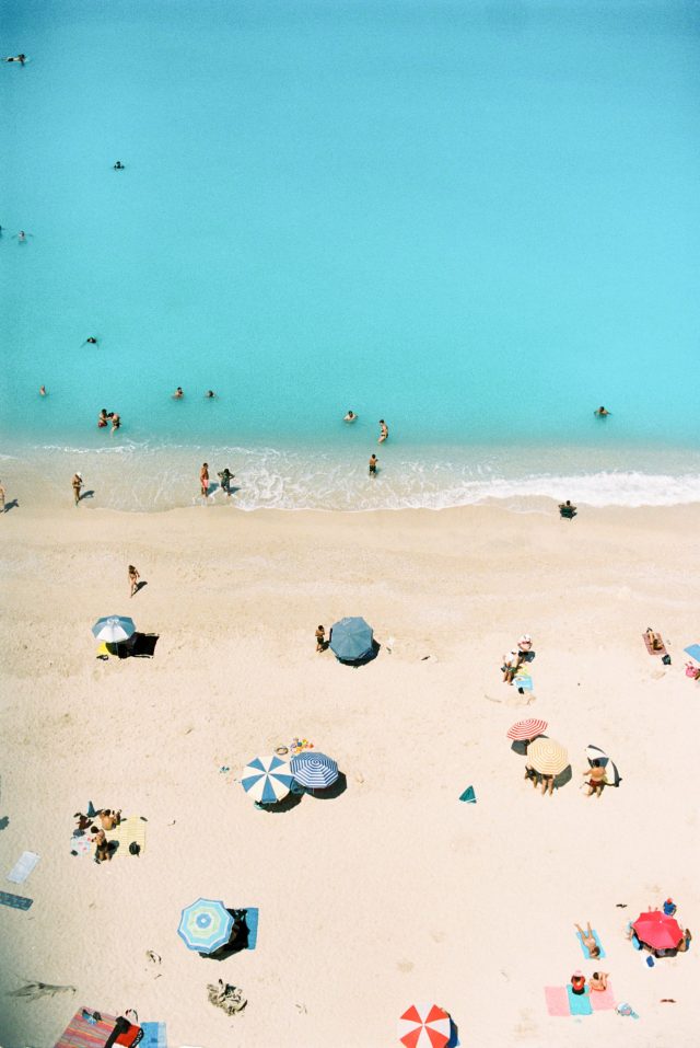 a beach with people and umbrellas