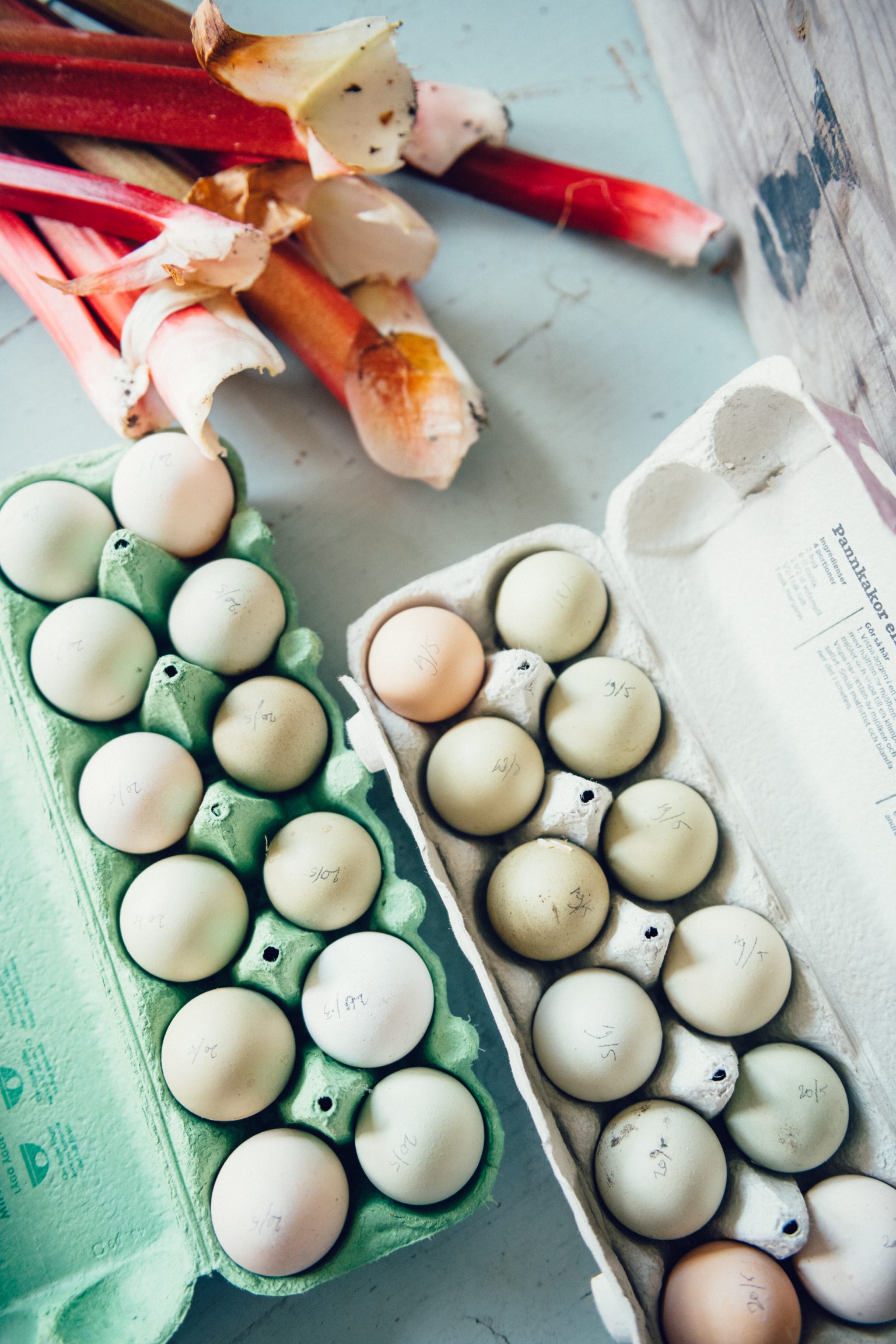 eggs in cartons next to a bunch of rhubarb