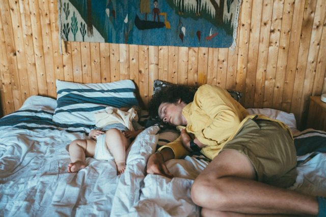 a man sleeping with a baby