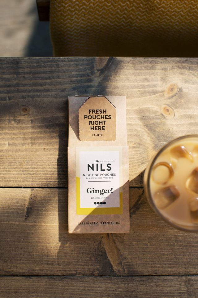 a box of ice tea next to a glass of ice