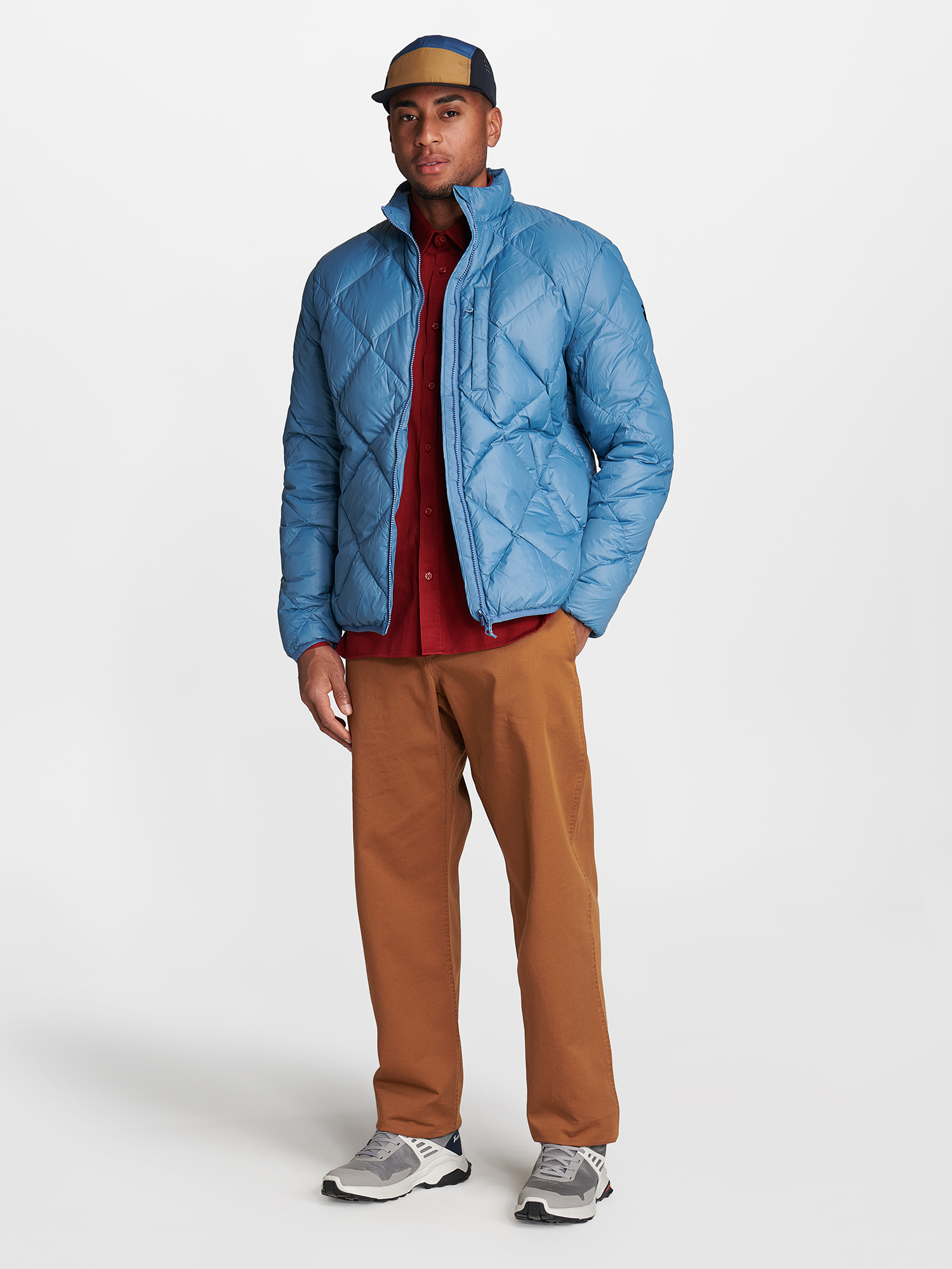 a man wearing a blue jacket and brown pants