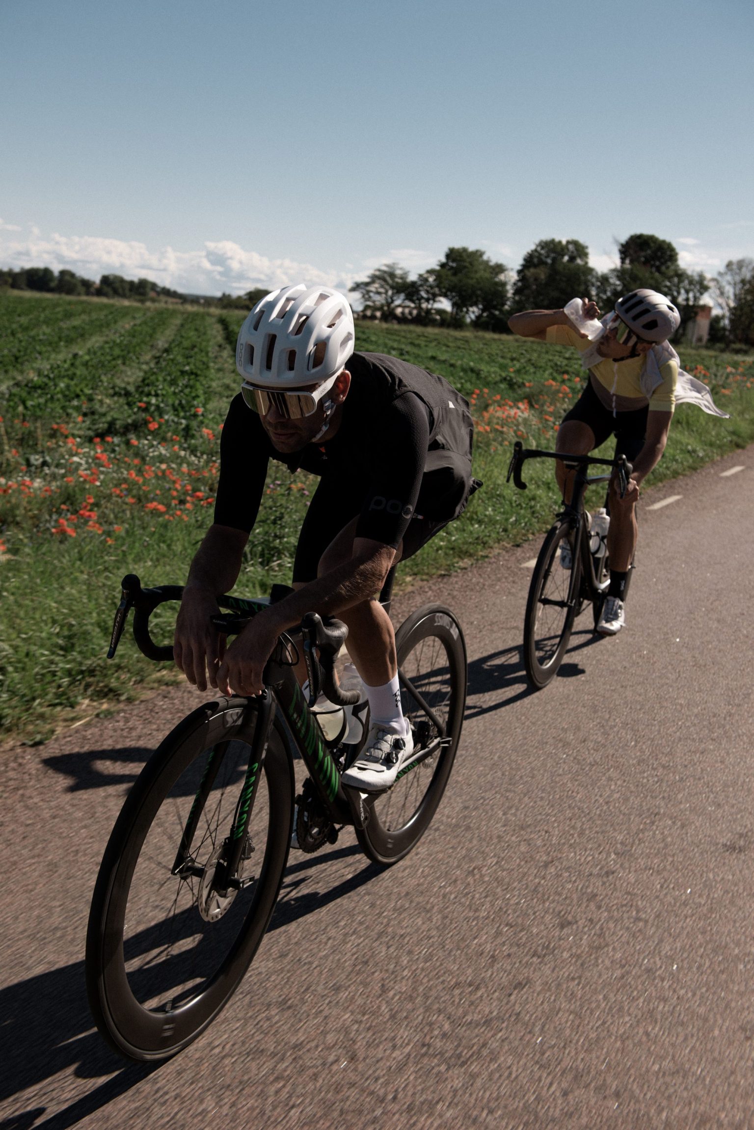 a couple of people riding bicycles on a road