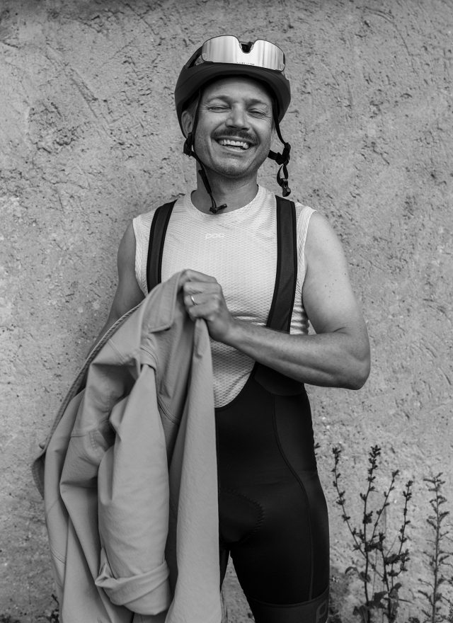 a man wearing a helmet and holding a jacket