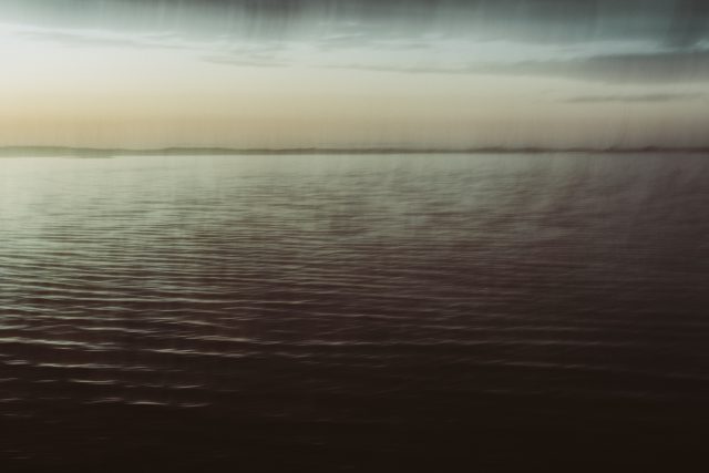 a body of water with a cloudy sky