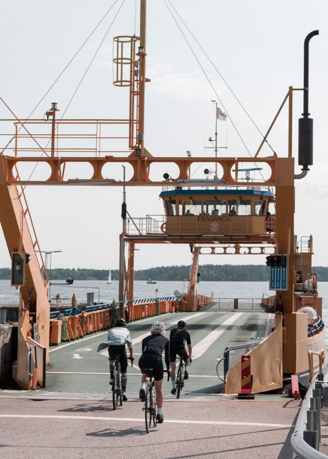 a group of people riding bikes on a bridge over water