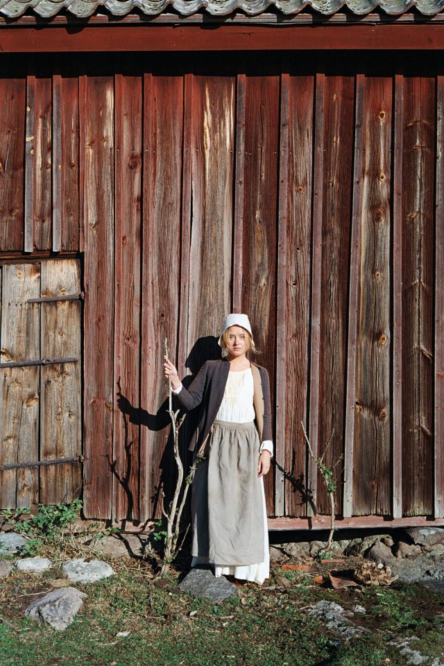 a woman standing in front of a wooden building