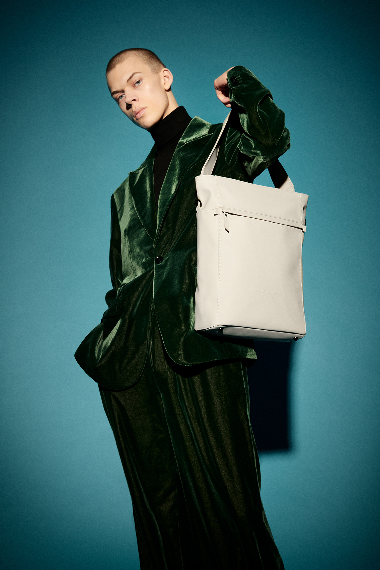 a man in a green suit holding a white bag
