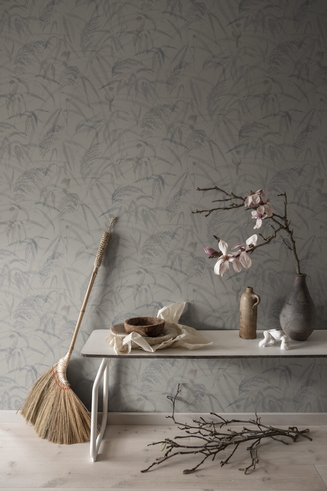 a table with a vase and a broom on it