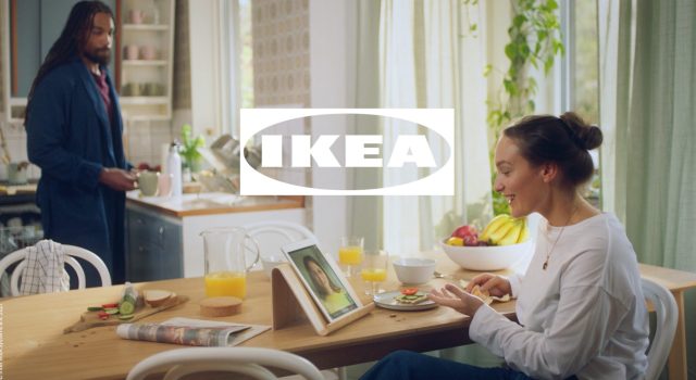 a woman sitting at a table with a tablet