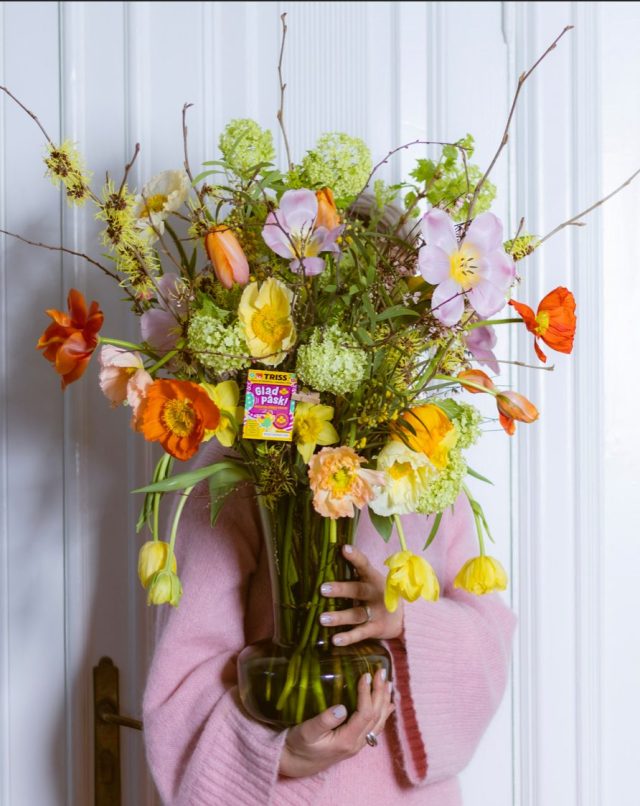 a person holding a vase of flowers