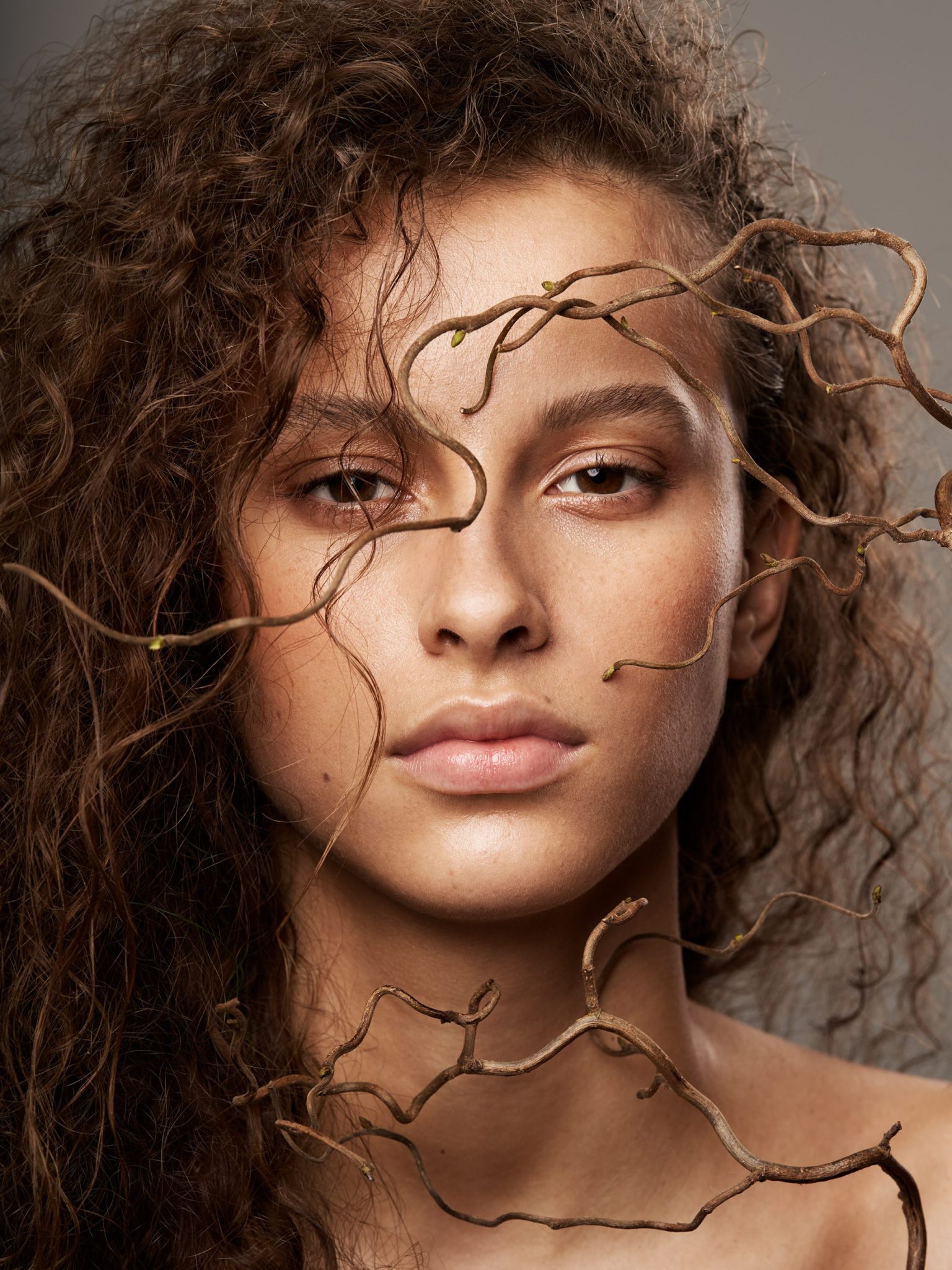 a woman with curly hair and bare shoulders