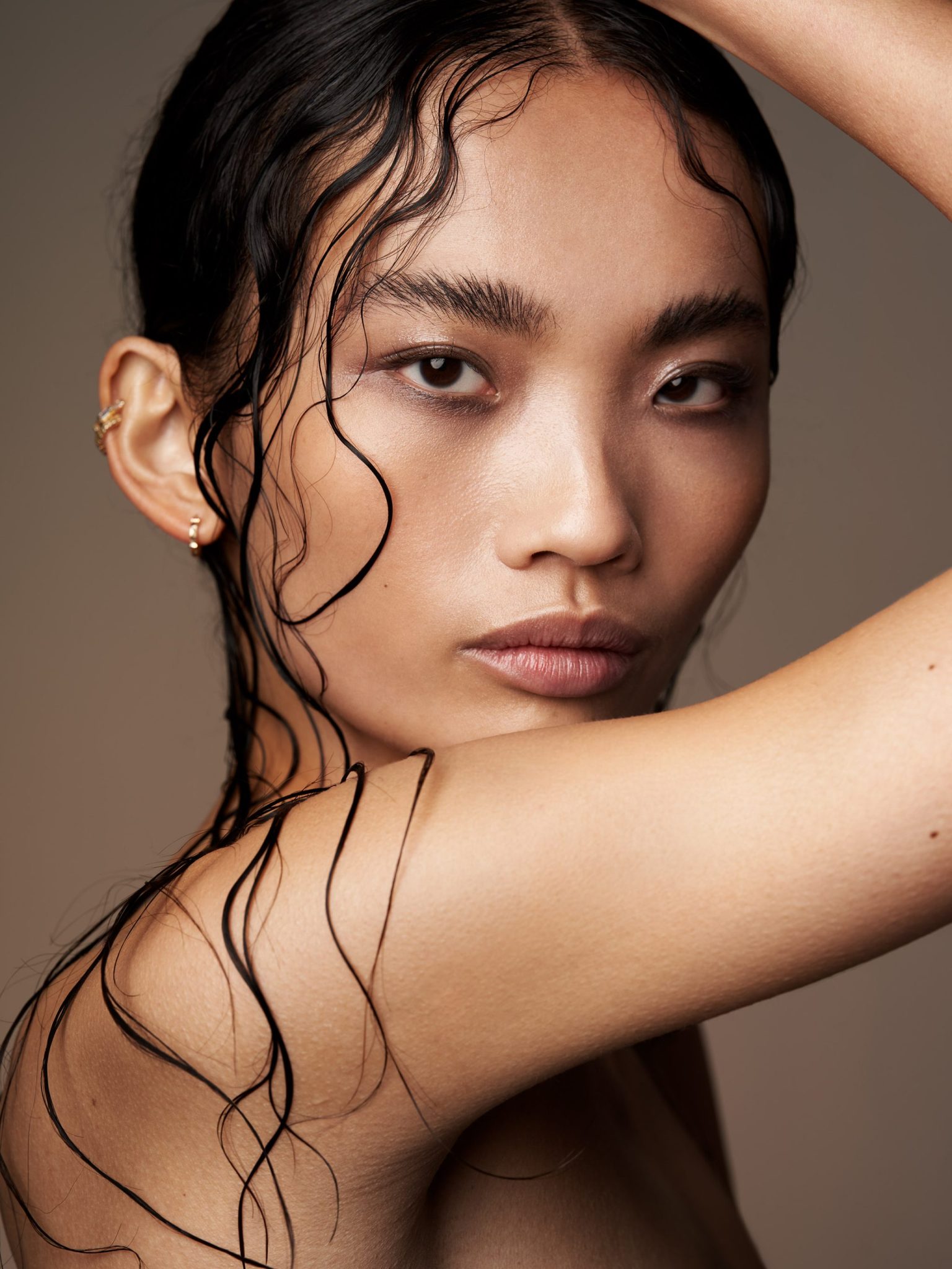 a woman with wet hair and a hand on her shoulder