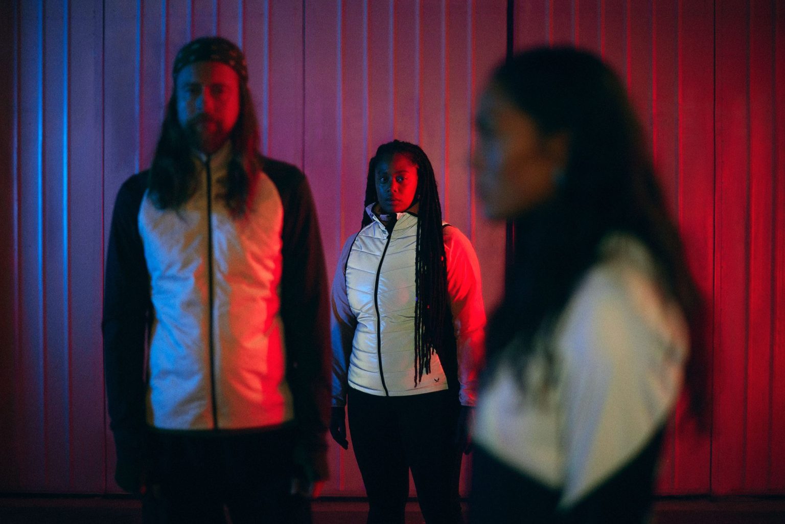 a group of people standing in front of a red and blue wall