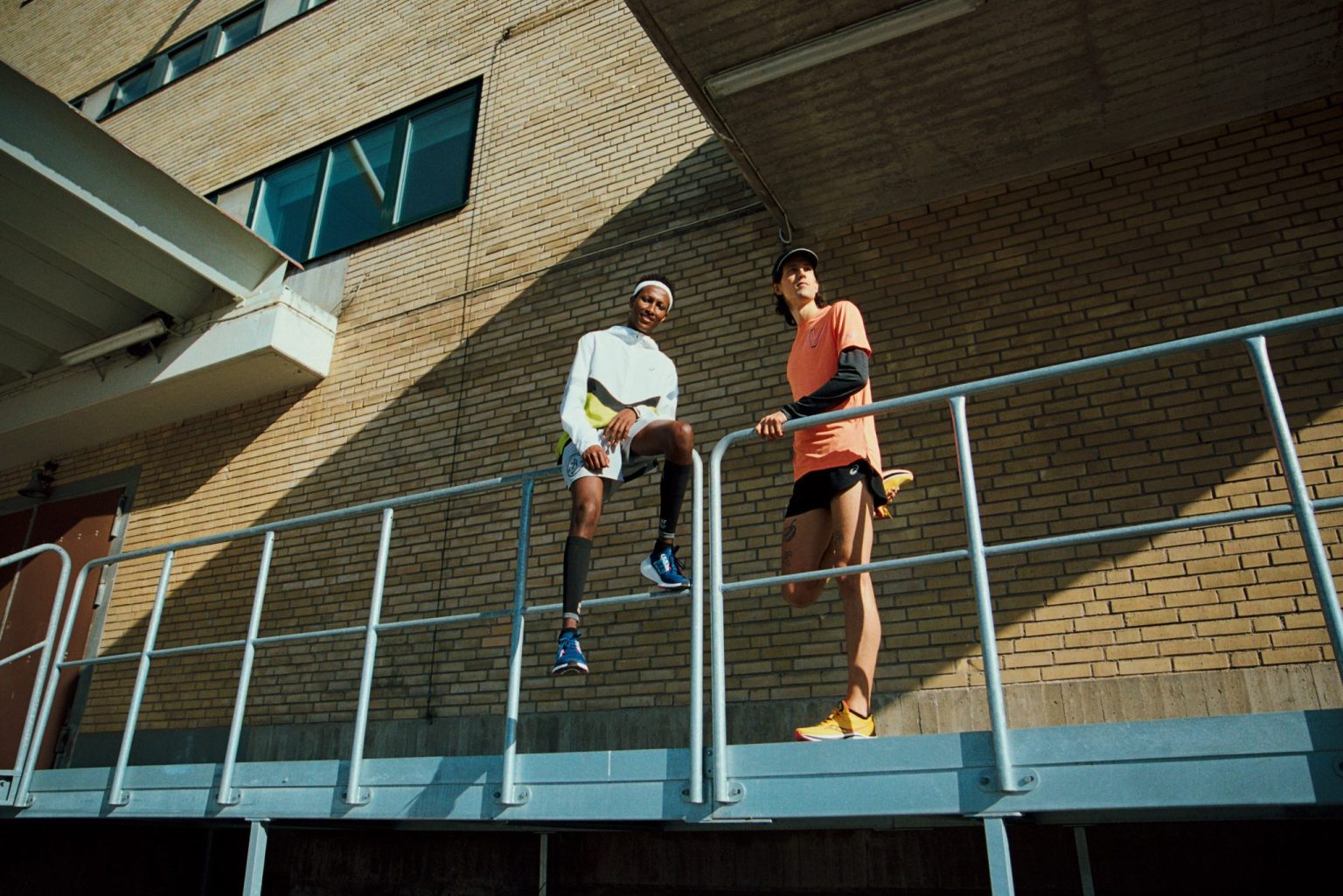 two men standing on a metal railing