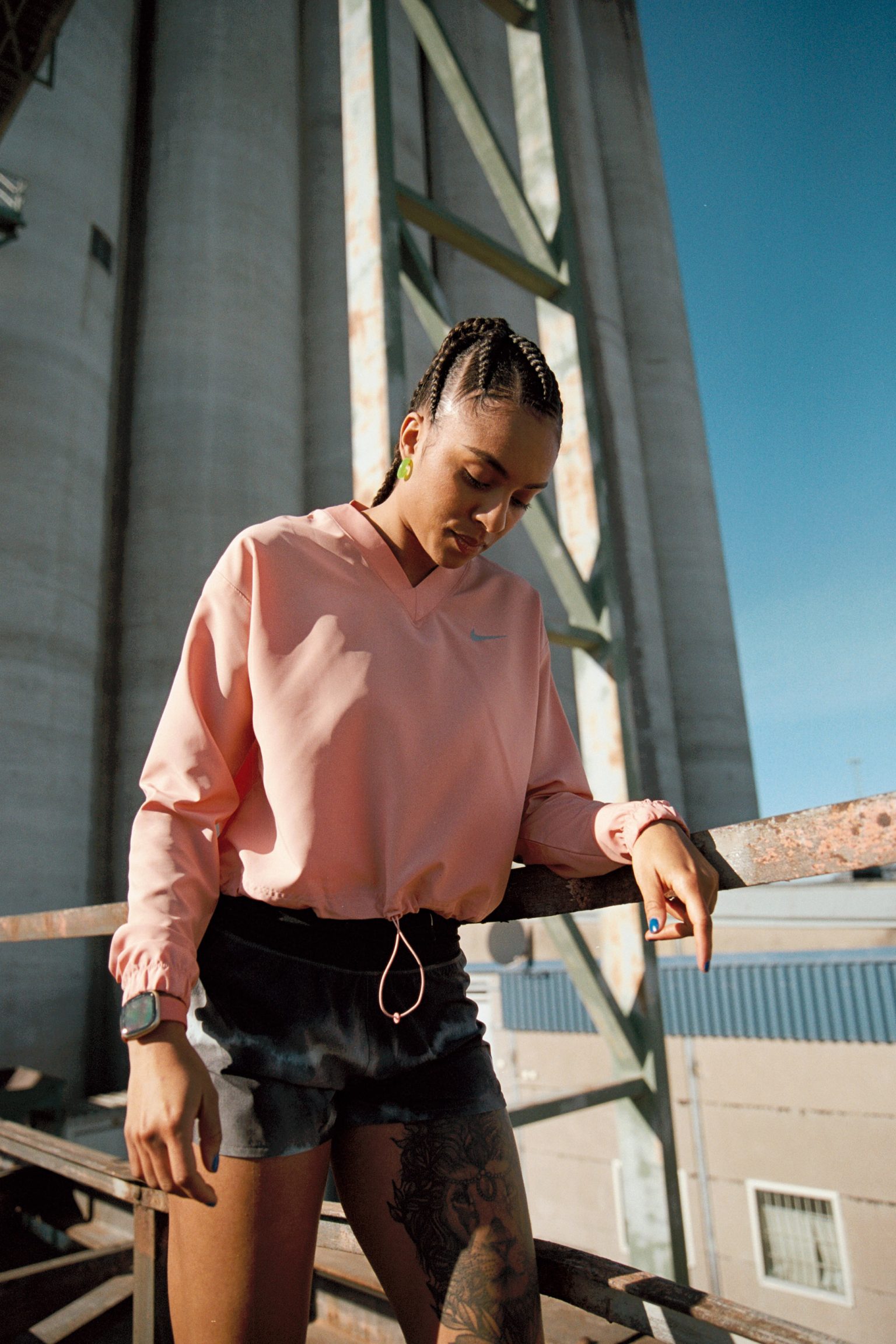 a woman leaning on a metal bar