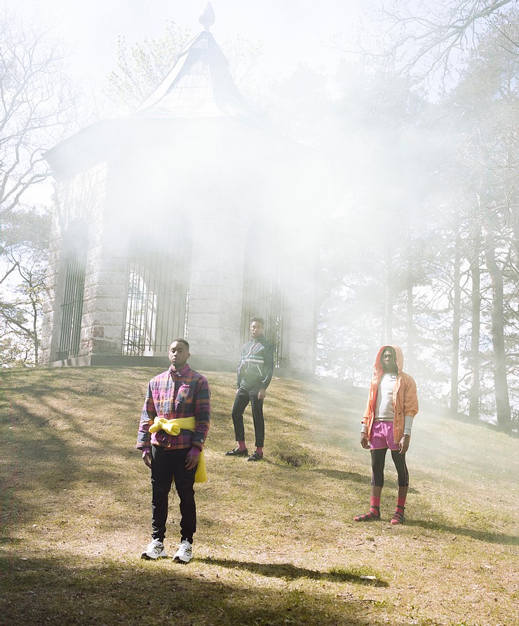 a group of people standing on a hill with smoke coming out of the ground