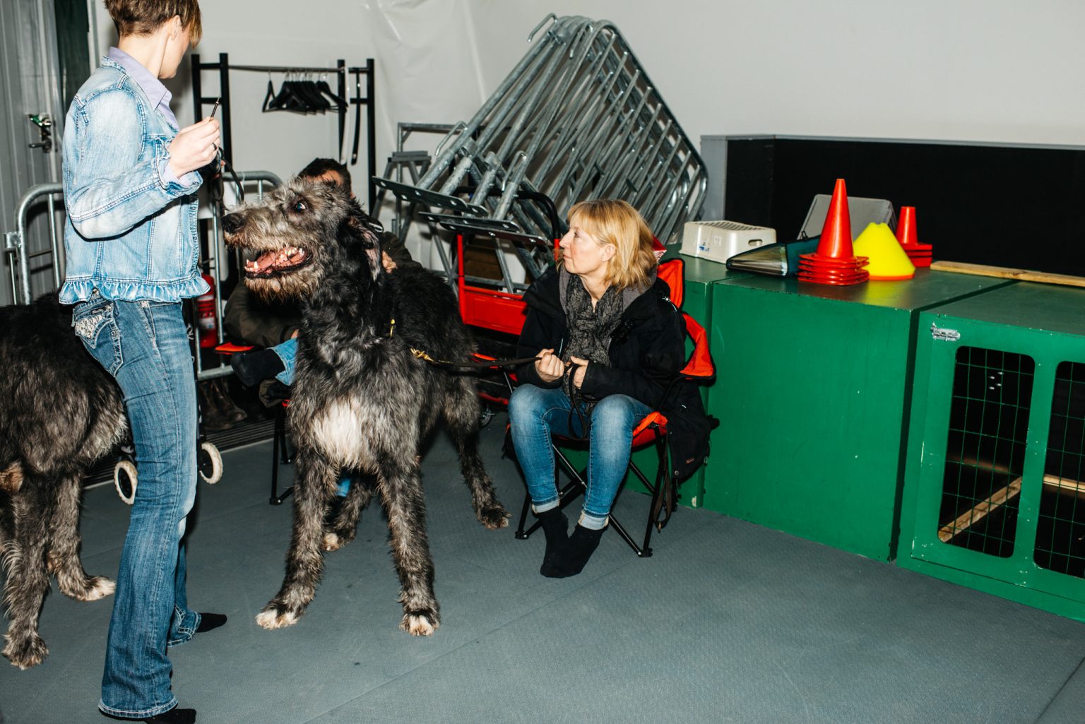 a woman standing next to a dog