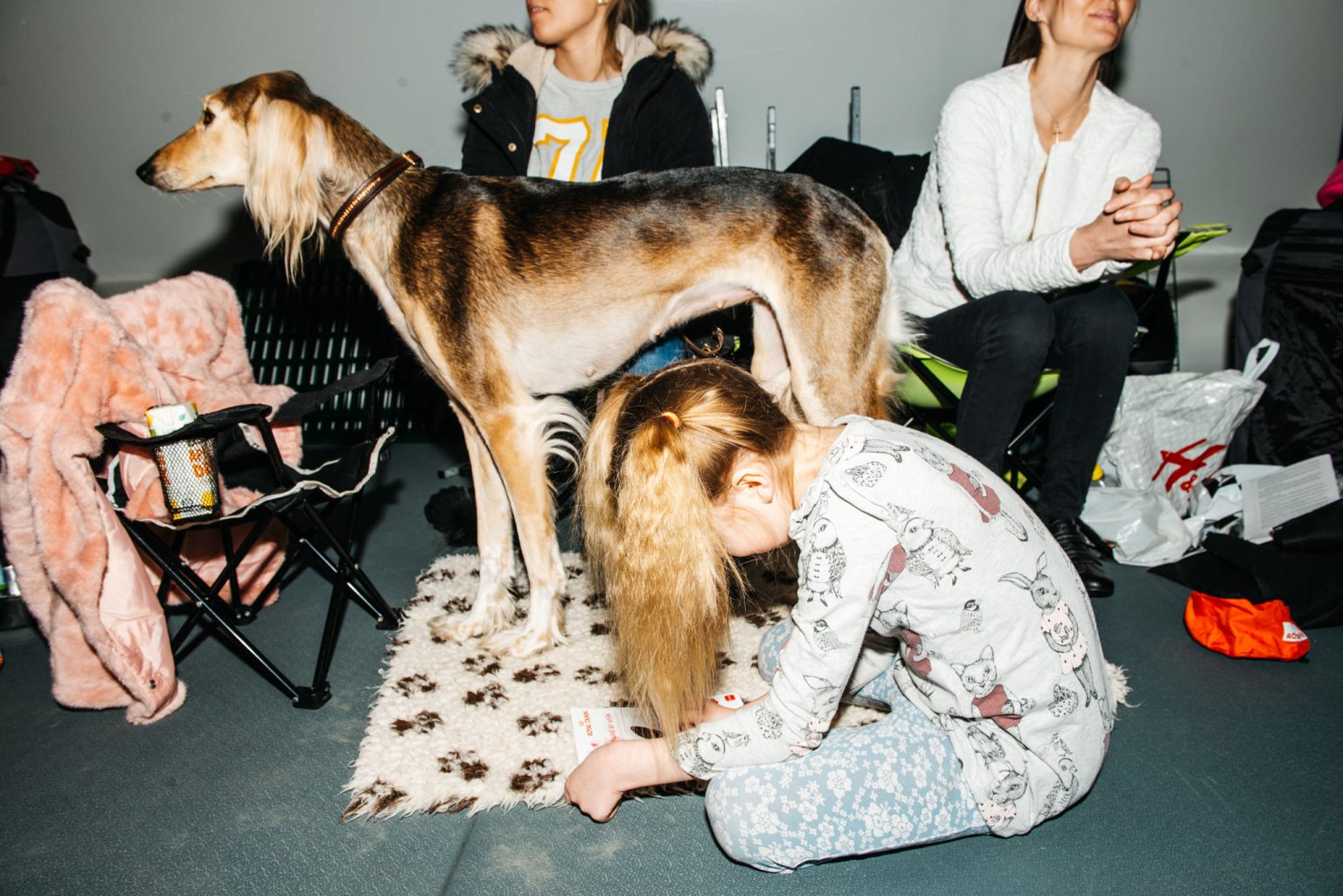 a girl sitting on the floor with a dog