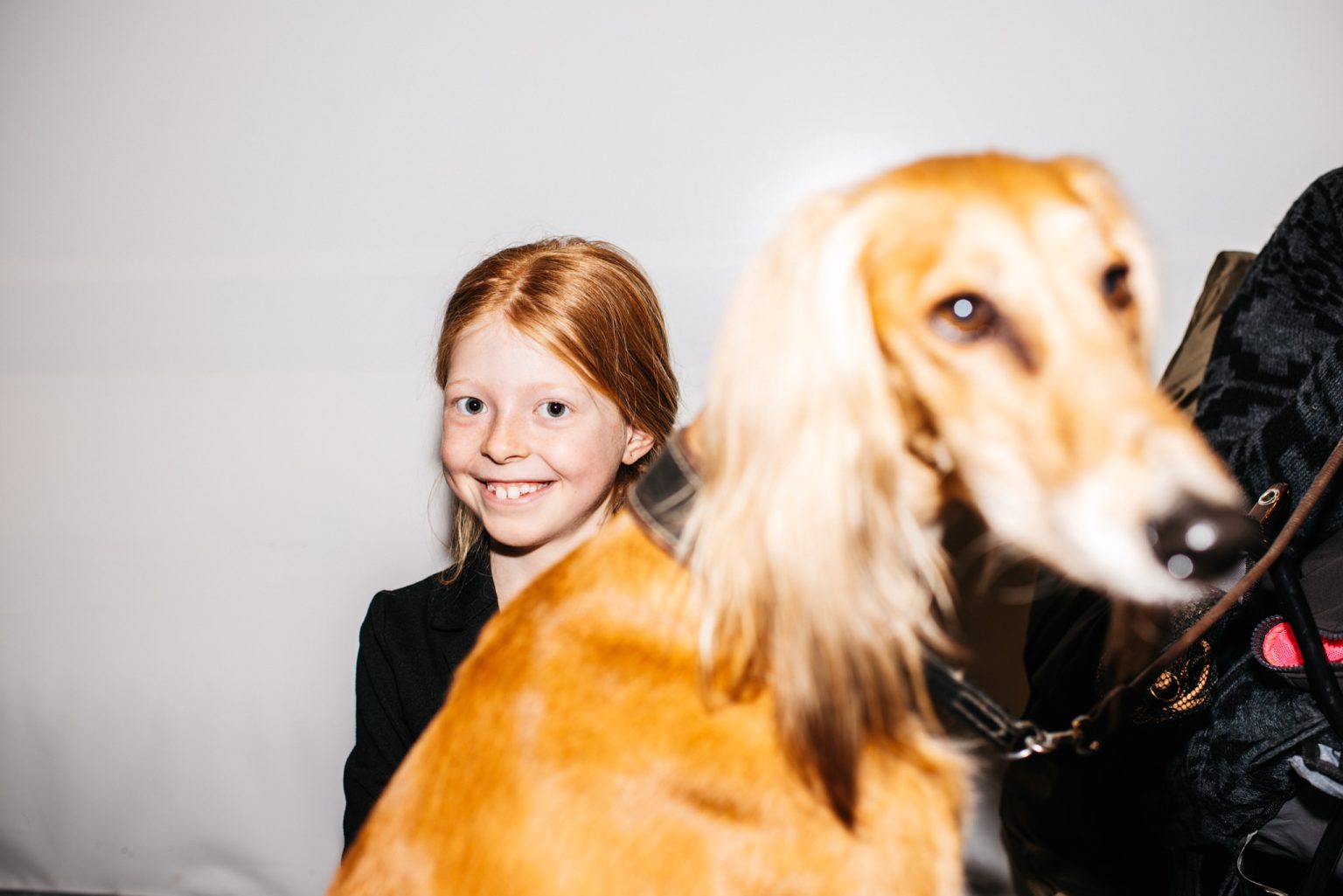 a girl smiling next to a dog