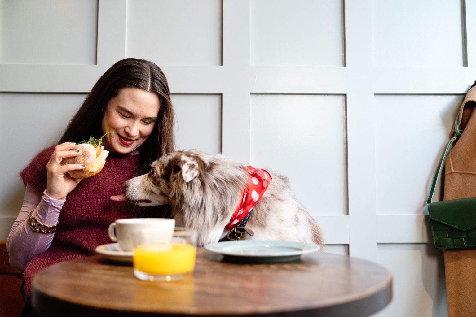 a woman and dog sitting at a table