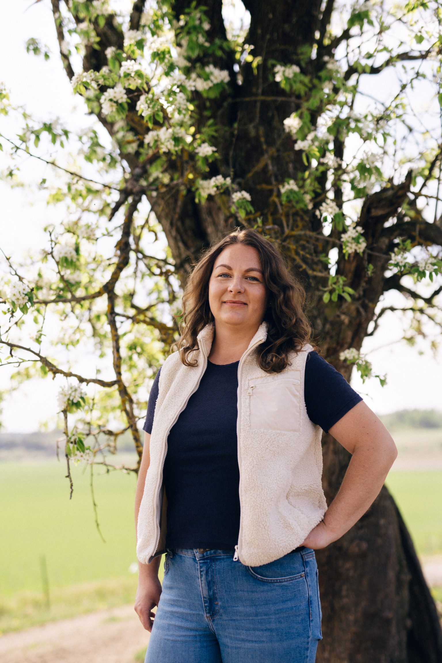 a woman standing in front of a tree