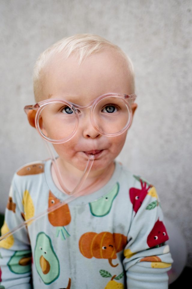 a child wearing glasses with a tube in his mouth