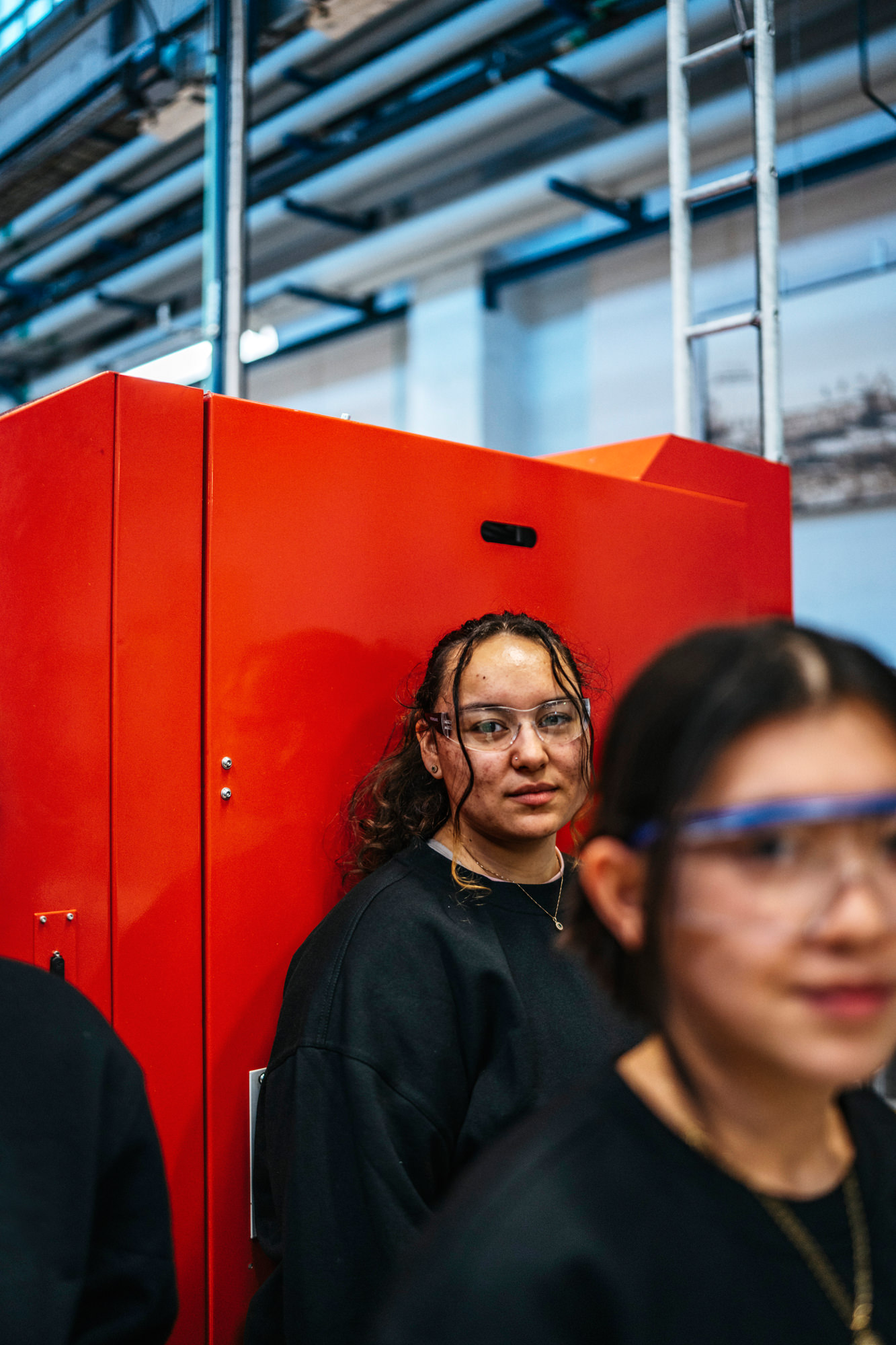 a woman standing next to a red machine