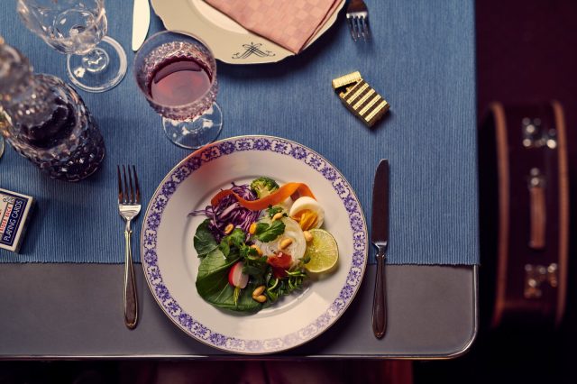 a plate of salad and wine glasses on a table