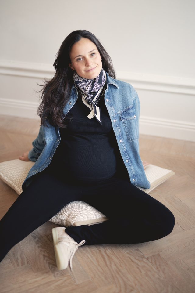 a pregnant woman sitting on a pillow