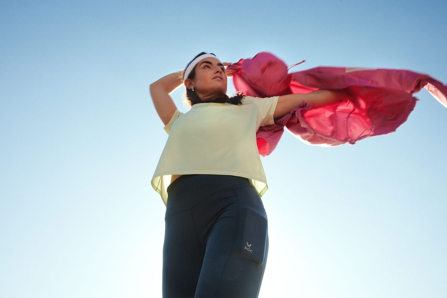 a woman holding a pink jacket